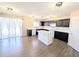 This bright kitchen features wood floors, an island, and dark cabinets at 22523 W Pima St, Buckeye, AZ 85326