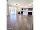 Bright, open living area features wood flooring, seamlessly connecting to the kitchen with dark cabinets at 22523 W Pima St, Buckeye, AZ 85326
