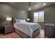 Cozy bedroom with hardwood floors, ambient lamps, and a large window with outside desert views at 24724 N 119Th Pl, Scottsdale, AZ 85255