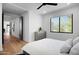 Bright bedroom with wood floors, ceiling fan, and a window view showcasing desert vegetation at 24724 N 119Th Pl, Scottsdale, AZ 85255