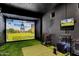 In-home golf simulator room featuring a large screen, putting green, and simulated outdoor course at 24724 N 119Th Pl, Scottsdale, AZ 85255