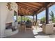 Inviting outdoor dining area with a fireplace, wooden beamed ceiling, and views of the desert landscape at 24724 N 119Th Pl, Scottsdale, AZ 85255