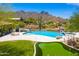 Inviting pool and putting green against mountain views, surrounded by well-manicured lawn and desert landscaping at 24724 N 119Th Pl, Scottsdale, AZ 85255