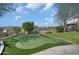 View of the backyard putting green surrounded by lush landscaping and hardscape at 24724 N 119Th Pl, Scottsdale, AZ 85255