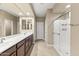 Bright bathroom featuring double sinks, tile flooring, and a walk-in shower at 25969 W Tina Ln, Buckeye, AZ 85396