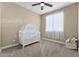 Cozy Bedroom featuring a crib, window, and plush carpeting at 25969 W Tina Ln, Buckeye, AZ 85396