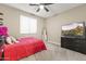 This cozy bedroom features a ceiling fan, large TV, and neutral colors throughout the space at 25969 W Tina Ln, Buckeye, AZ 85396