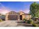 Inviting single-story home featuring a well-kept lawn, desert landscaping, and a two-car garage for modern living at 25969 W Tina Ln, Buckeye, AZ 85396