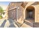A close-up of the home's front door and arched entryway, plus a view of the attached garage at 25969 W Tina Ln, Buckeye, AZ 85396