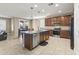 Well-lit kitchen with dark wood cabinets, stainless steel appliances and a dining table with chairs at 25969 W Tina Ln, Buckeye, AZ 85396