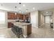 An open-concept kitchen with dark wood cabinets, granite countertops, and stainless steel appliances at 25969 W Tina Ln, Buckeye, AZ 85396