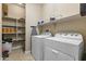 Convenient laundry room equipped with shelving for storage and modern washer and dryer appliances at 25969 W Tina Ln, Buckeye, AZ 85396