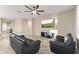 Spacious living room with two leather sofas, tile floors, and a ceiling fan at 25969 W Tina Ln, Buckeye, AZ 85396