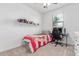 This bedroom includes a shelf filled with hats and a desk with a computer and gaming chair at 37287 N Azteca Rd, San Tan Valley, AZ 85140