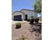 Home exterior with desert landscaping, blue sky, and a glimpse of the front window at 37287 N Azteca Rd, San Tan Valley, AZ 85140