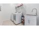 Well-equipped laundry room with washer, dryer, sink, and ample storage shelves at 37287 N Azteca Rd, San Tan Valley, AZ 85140