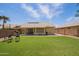 Backyard featuring artificial grass, mature trees, and a seating area perfect for entertaining at 3821 N 125Th Dr, Avondale, AZ 85392