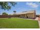 Backyard featuring artificial grass, mature trees, and a seating area perfect for entertaining at 3821 N 125Th Dr, Avondale, AZ 85392