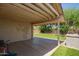 Covered backyard patio with a grill, overlooking a manicured lawn with mature trees at 3821 N 125Th Dr, Avondale, AZ 85392