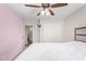 A serene bedroom with a ceiling fan, and an open door to the bathroom at 3821 N 125Th Dr, Avondale, AZ 85392