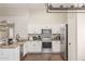 Bright kitchen with white cabinets, granite countertops, stainless steel appliances, and hardwood floors at 3821 N 125Th Dr, Avondale, AZ 85392