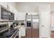 Stainless steel refrigerator and appliances complement granite countertops, white cabinets, and mosaic backsplash at 3821 N 125Th Dr, Avondale, AZ 85392
