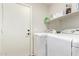 Laundry room with white appliances and shelves, offering practical storage solutions at 3821 N 125Th Dr, Avondale, AZ 85392