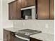 Close-up view of the kitchen featuring stainless steel appliances and dark cabinets at 4035 S 176Th Dr, Goodyear, AZ 85338