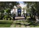 Charming home entrance featuring lush landscaping, a brick walkway, and an impressive arched doorway at 5610 E Sanna St, Paradise Valley, AZ 85253
