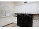 Functional laundry room equipped with modern black washer and dryer units and plenty of cabinet space at 5610 E Sanna St, Paradise Valley, AZ 85253