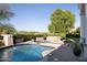 Relaxing pool area with a hot tub, putting green, well maintained foliage, and beautiful brick patio at 5610 E Sanna St, Paradise Valley, AZ 85253