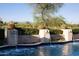 Beautiful pool featuring potted cacti atop pillars with cascading waterfalls and mountain views in the background at 5610 E Sanna St, Paradise Valley, AZ 85253