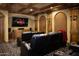 Luxurious home theater room features black leather seating, wood trim, and a large screen for immersive entertainment at 5610 E Sanna St, Paradise Valley, AZ 85253