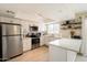 Well-lit kitchen with white cabinetry, stainless appliances, open shelving, and modern finishes at 6005 N Granite Reef Rd, Scottsdale, AZ 85250