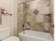 Bathroom featuring shower-tub combo with tile surround and decorative inlay, plus a commode at 608 E Stonebridge Dr, Gilbert, AZ 85234