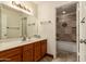 Bathroom showcasing tile flooring, a shower-tub, and wooden sink cabinetry with vanity mirror at 608 E Stonebridge Dr, Gilbert, AZ 85234