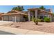 Charming single-story home featuring a red tile roof, a three-car garage, and desert landscaping at 608 E Stonebridge Dr, Gilbert, AZ 85234