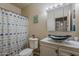 Well-lit bathroom with stylish blue sink bowl, modern toilet, and patterned shower curtain at 6154 S Borego Rd, Gold Canyon, AZ 85118