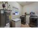Efficient laundry room featuring washer, dryer, deep freezer, and storage shelves at 6154 S Borego Rd, Gold Canyon, AZ 85118
