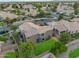 Aerial view of a backyard with green lawn, mature trees, a gray home with a tile roof and a neighborhood at 630 W Saragosa St, Chandler, AZ 85225