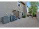 Exterior view of home with small backyard, gravel, patio, and AC unit outside the back entrance at 630 W Saragosa St, Chandler, AZ 85225