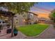 A plush lawn leads to a stone patio with an outdoor seating area, with mature trees surrounding the yard at 630 W Saragosa St, Chandler, AZ 85225