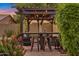Outdoor patio area showing covered pergola with outdoor bar, cushioned seating, and lush backyard plants at 630 W Saragosa St, Chandler, AZ 85225