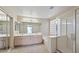 Bright bathroom with double sinks, glass block window, and separate shower and tub at 6923 W Laredo St, Chandler, AZ 85226