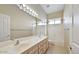Bright bathroom featuring a double sink vanity, large mirror, and a shower-tub combo with natural light at 6923 W Laredo St, Chandler, AZ 85226