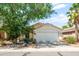 Charming single-story home with a well-manicured lawn, mature tree, and a two-car garage at 742 E Lovegrass Dr, San Tan Valley, AZ 85143