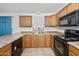 Well-lit kitchen features wooden cabinets, dual basin sink, and black appliances at 742 E Lovegrass Dr, San Tan Valley, AZ 85143