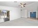 Spacious living room with neutral carpet, vaulted ceiling, and sliding door access to a covered patio at 742 E Lovegrass Dr, San Tan Valley, AZ 85143