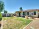 Wide backyard featuring a patio, storage shed, green lawn, and desert landscaping at 8140 W Lane Ave, Glendale, AZ 85303