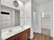 Bathroom with double sinks, wood-look flooring, and a walk-in closet at 8140 W Lane Ave, Glendale, AZ 85303